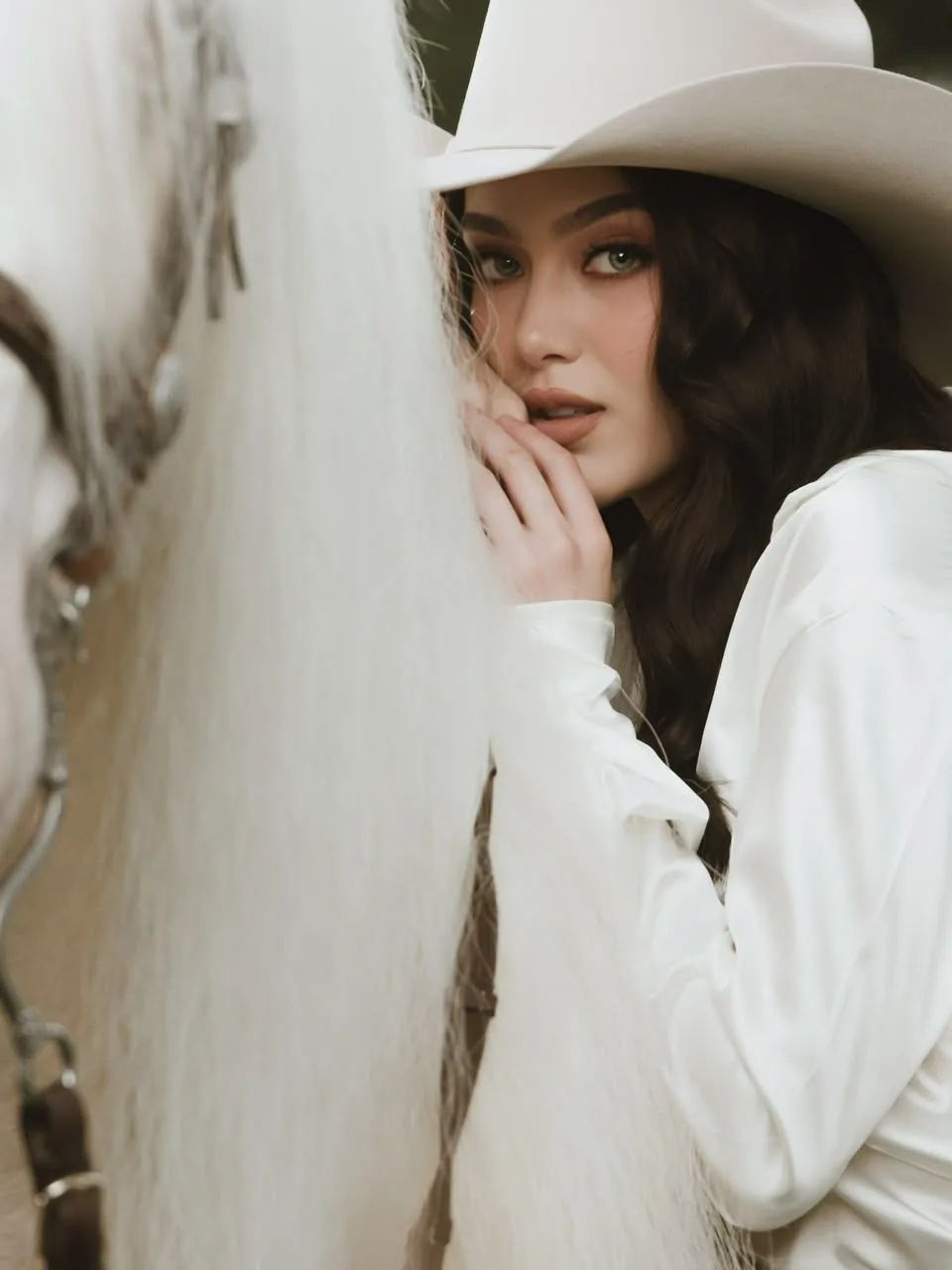 Retrato con sombrero junto a la crin de un Gypsy Vanner